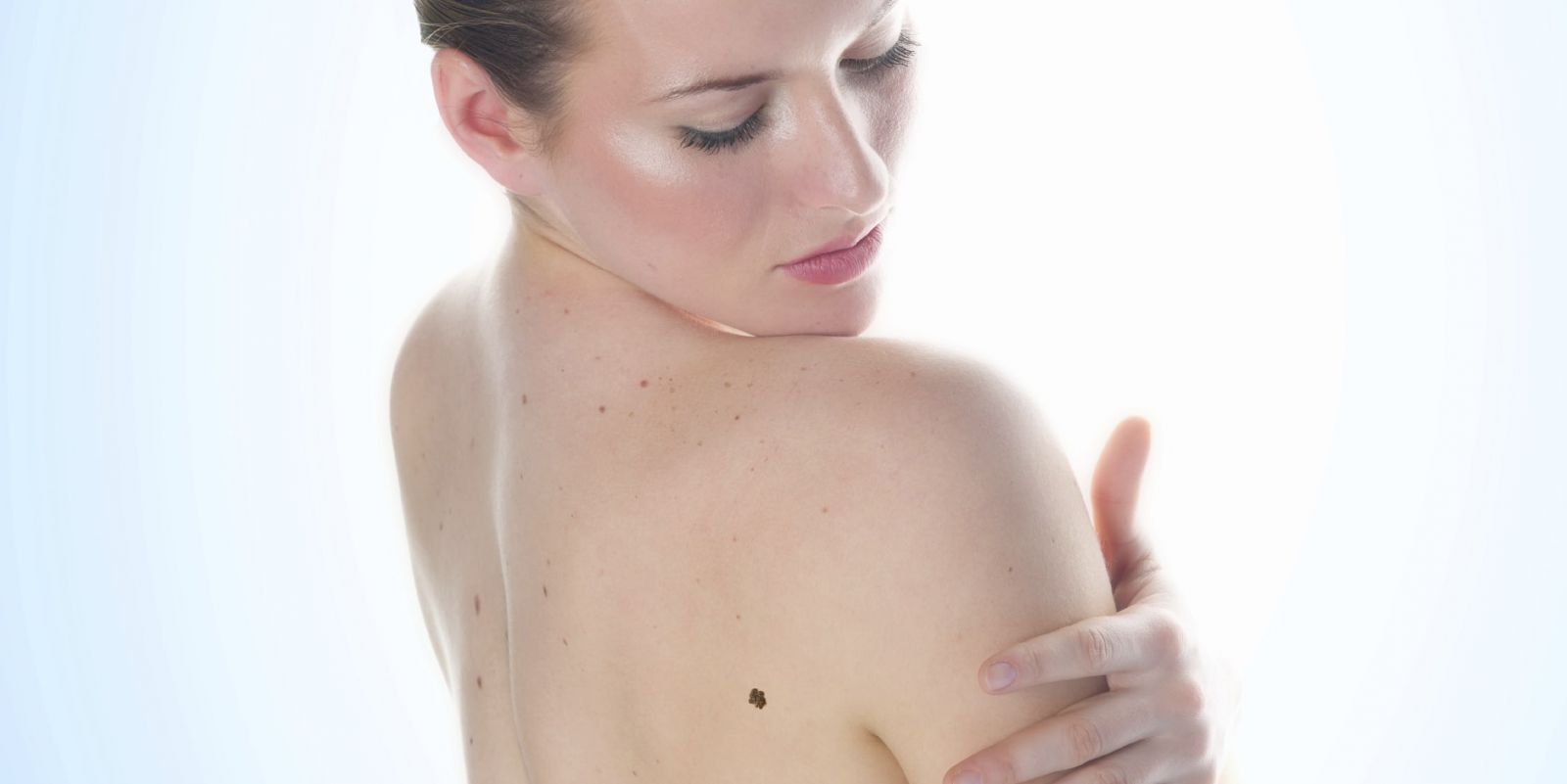 Female Looking Back Over Bare Shoulder At Large Brown Mole