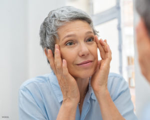 mature older woman Pulling Back Wrinkles On Eye Corner